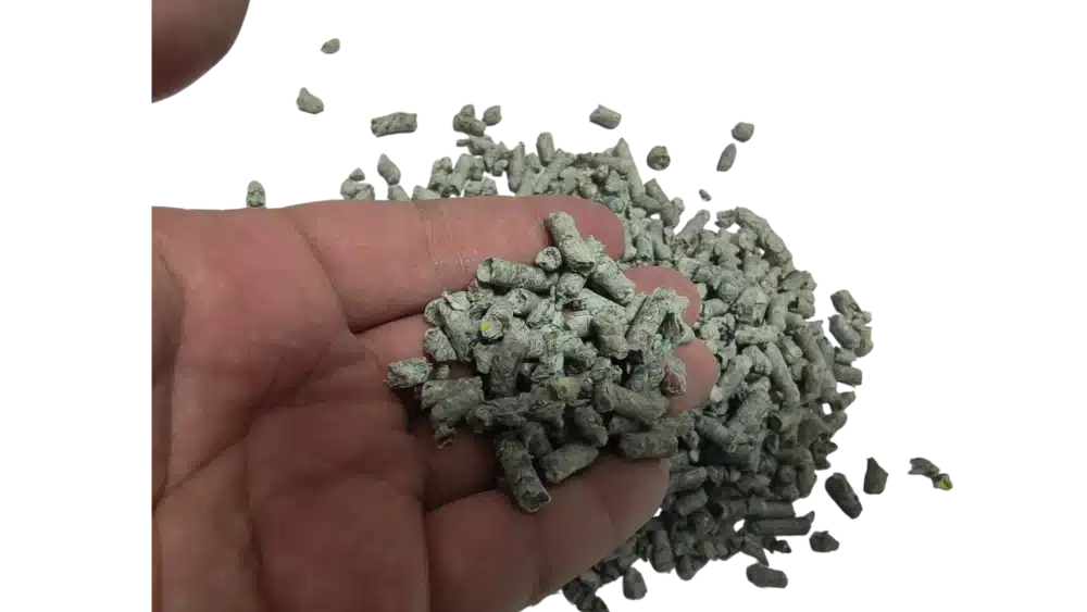 Recycled newspaper cat litter pellets pouring from hand